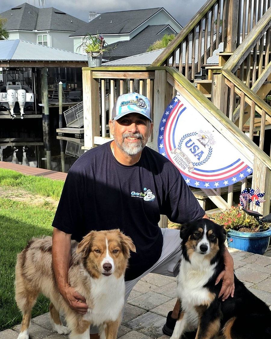 David Gonzalez, owner of ClearFlow Jax, at home in Jacksonville with his two Australian shepherds